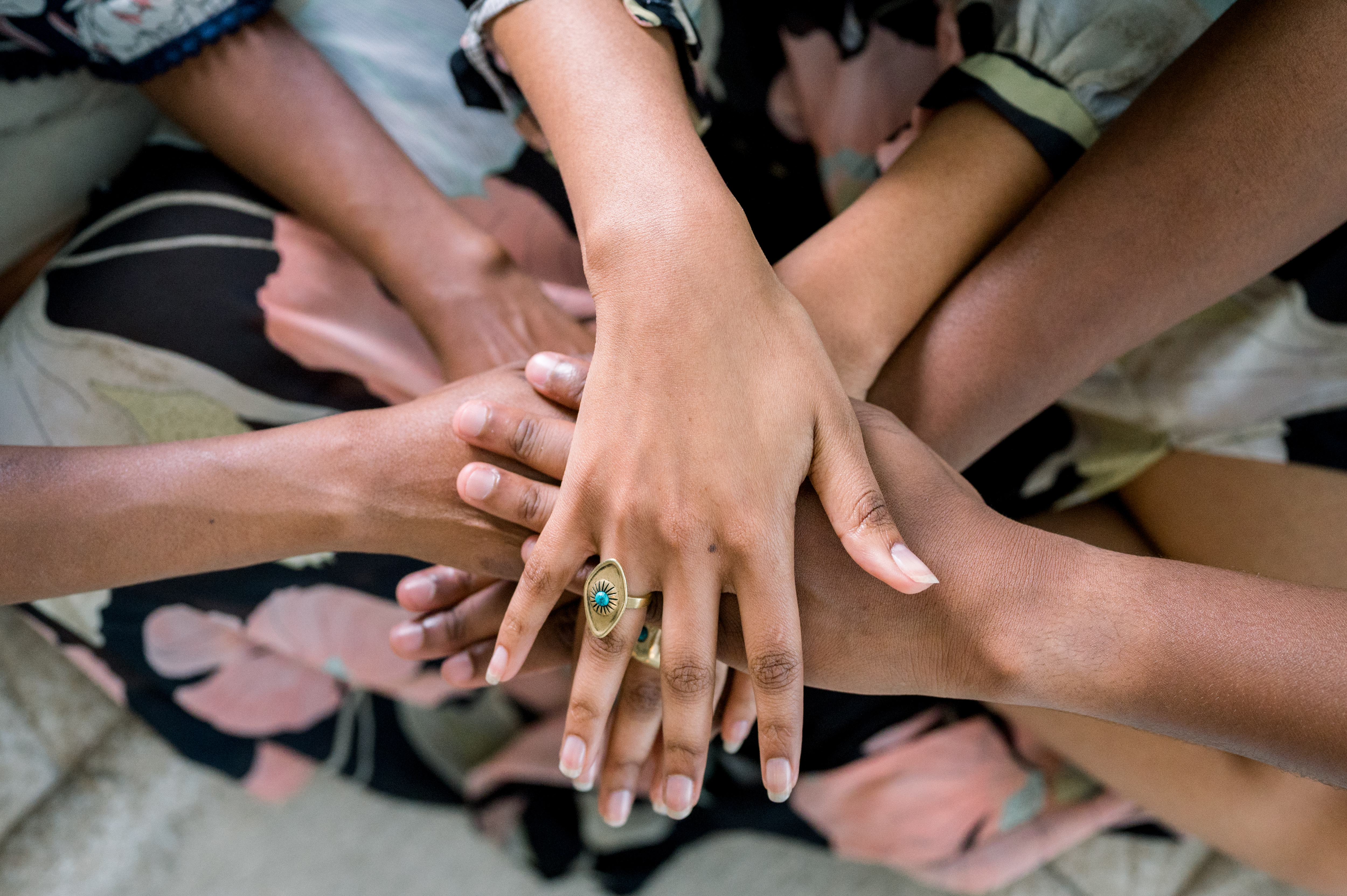 hands of women from a variety of cultures in a gesture of teamwork and unity